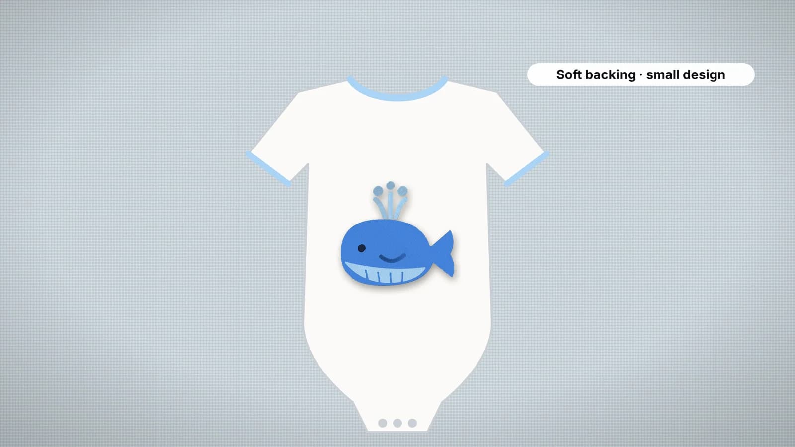 A white baby onesie with a small blue whale embroidered on the chest