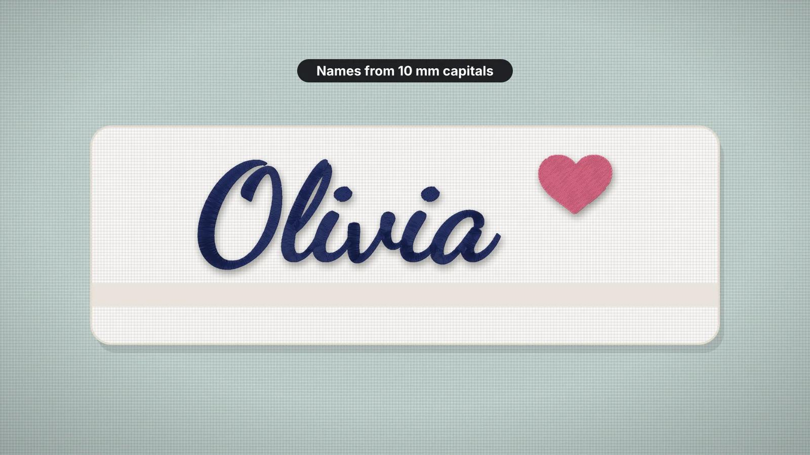 A folded white towel with the name Olivia stitched in navy script next to a pink heart