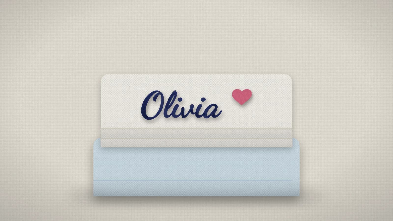 Folded towels with the name Olivia embroidered in navy script above the border